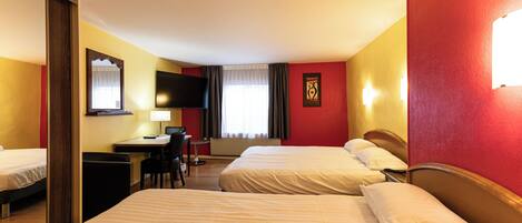 Quarto de hotel com duas camas, uma escrivaninha com cadeira, televisão e janela com cortinas.