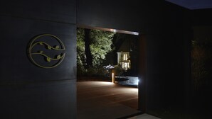 A modern building entrance with a circular logo, a wooden floor, and a well-lit interior. - Moulin des Templiers Hôtel & SPA (Pontaubert)