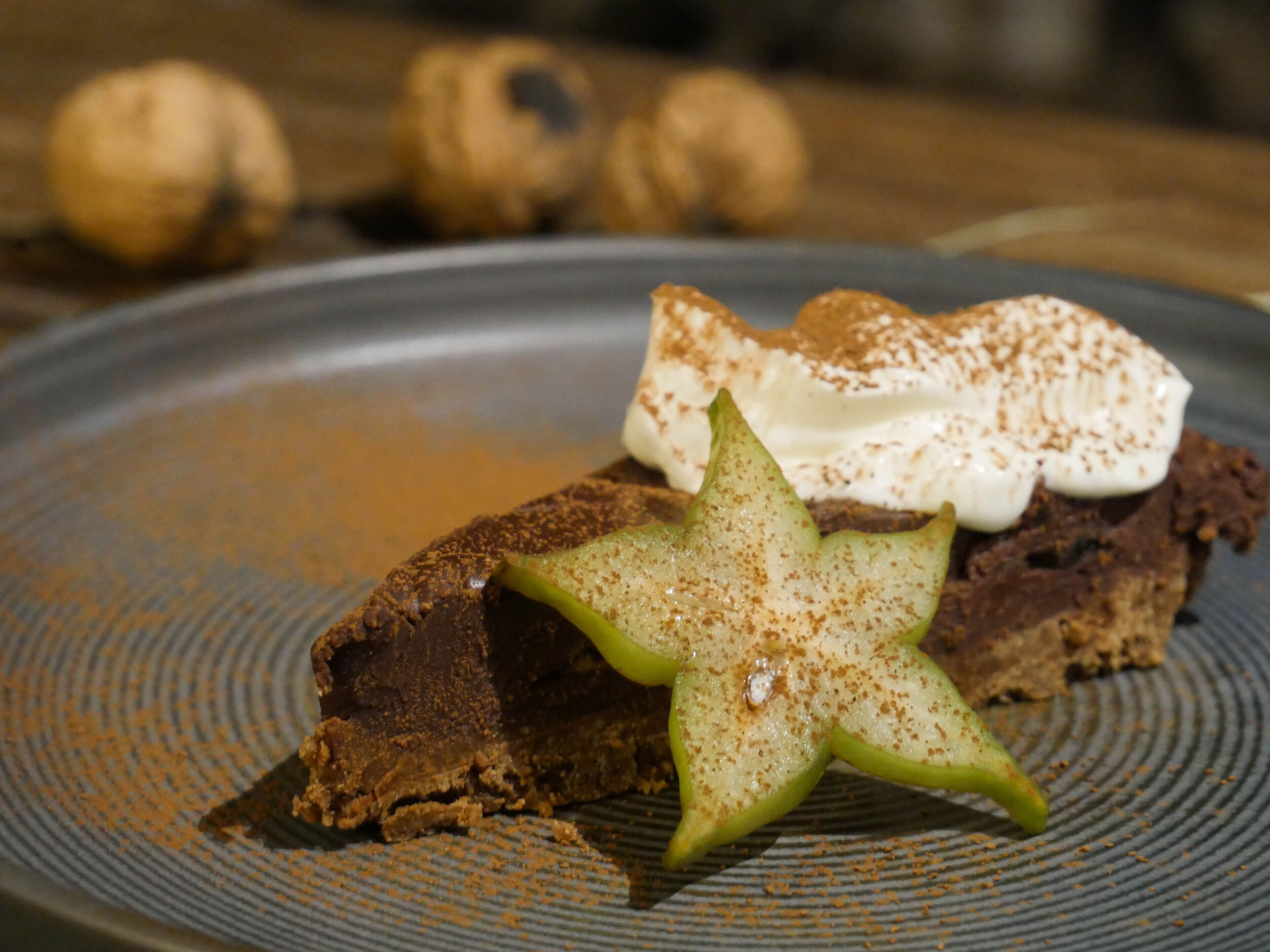 Un postre en un plato con un adorno con forma de estrella y un poco de canela espolvoreada.