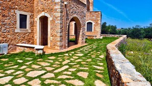 A stone building with a paved courtyard and arched doorways. - Villas and Bungalows (Apokoronas)