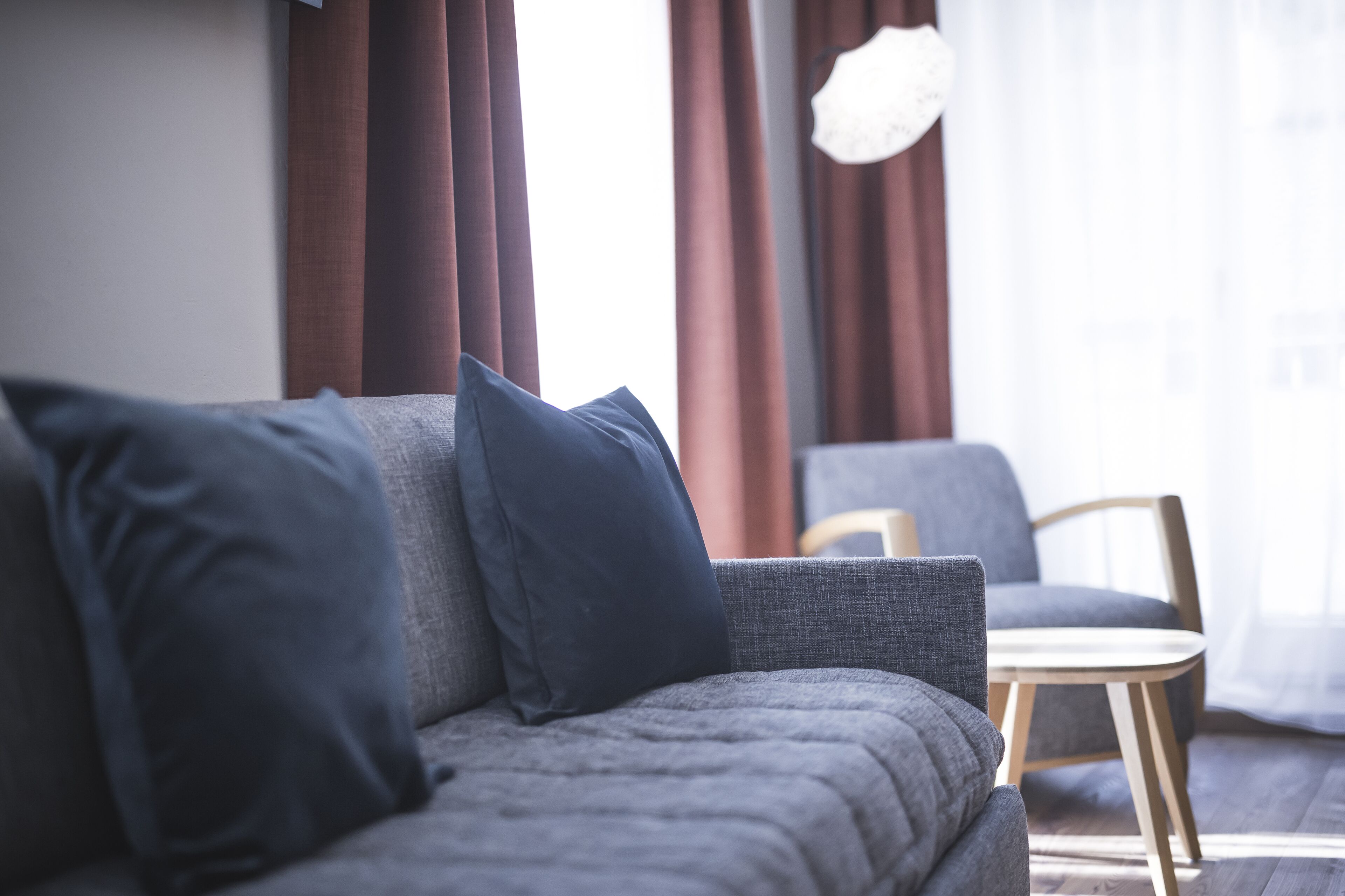 A modern living room with a grey sofa and a small wooden table.