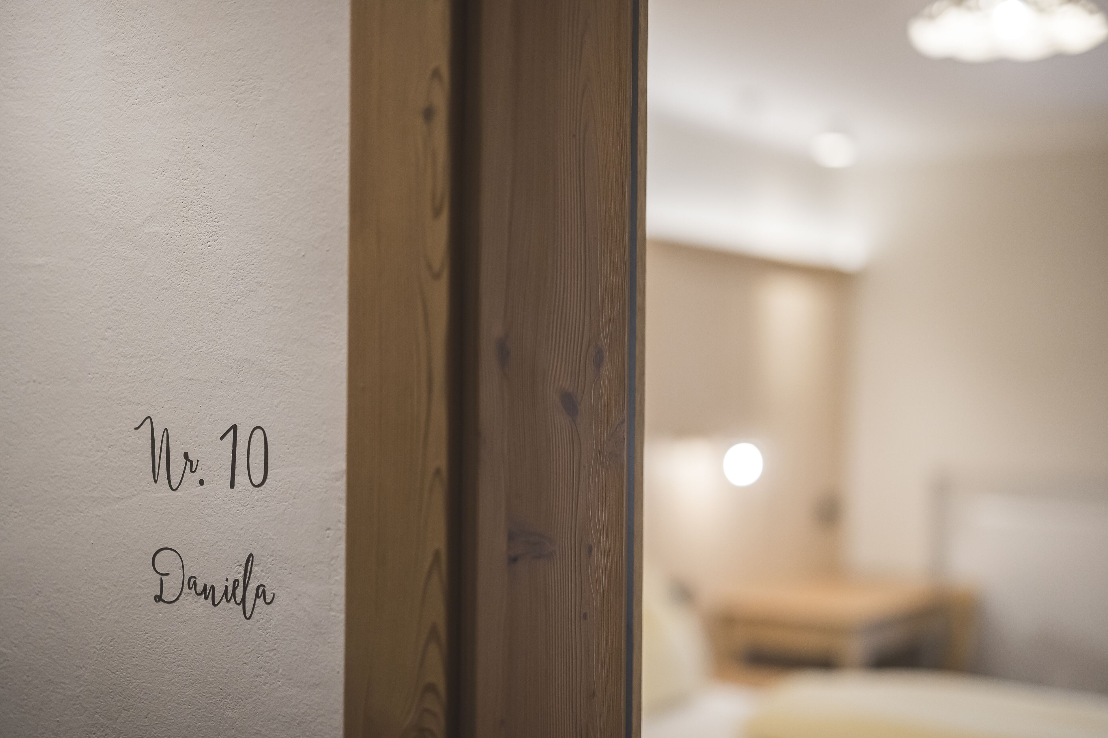 Una puerta de madera con una pared blanca y un fondo desenfocado.