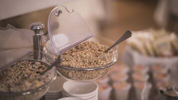 Een buffet met diverse etenswaren, waaronder ontbijtgranen en andere snacks.