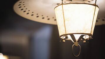 A hanging lantern with a metal frame and a glass enclosure, suspended from a ceiling fixture.