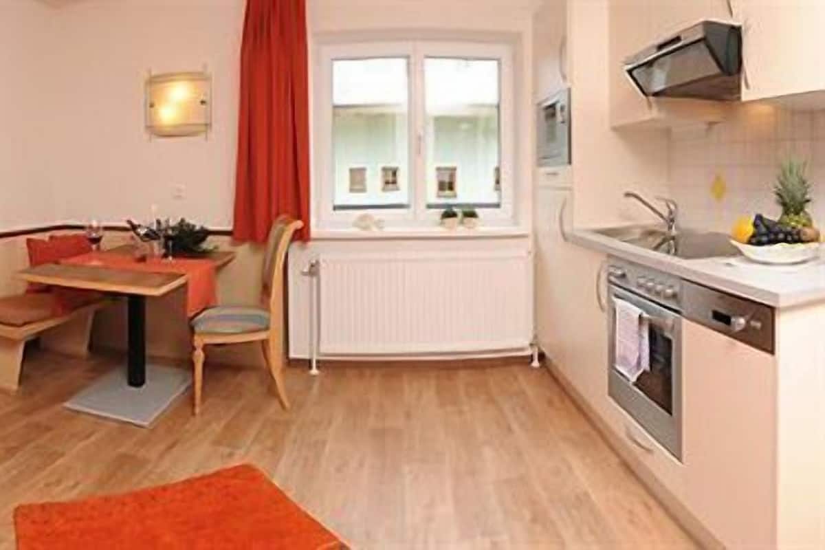 A compact living space with a kitchenette, a dining area, and a seating area.
