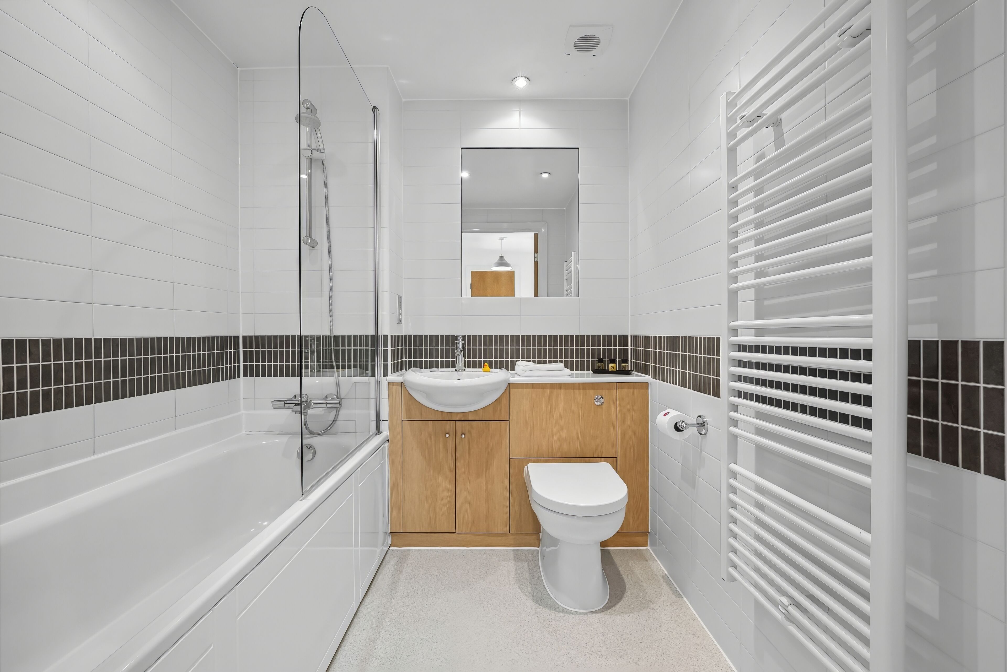 Une salle de bain moderne équipée d’une baignoire, d’une douche, d’un lavabo et de toilettes.