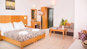 A hotel room with a large bed, a desk, a sofa, and a dining table.
