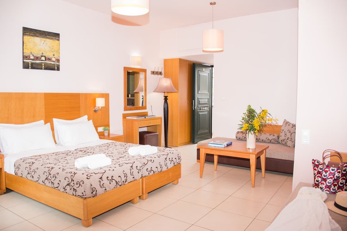 Una camera d'albergo con un letto grande, una scrivania, un divano e un tavolo da pranzo.