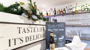 A bar area with a sign reading "TASTE LIFE IT'S DELICIOUS", a bottle of Tangero Blond beer, and a white star-shaped decoration with "Merry Xmas". - Huis ter Geul (Valkenburg aan de Geul)