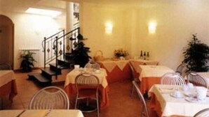 Un comedor con varias mesas, sillas y una escalera.