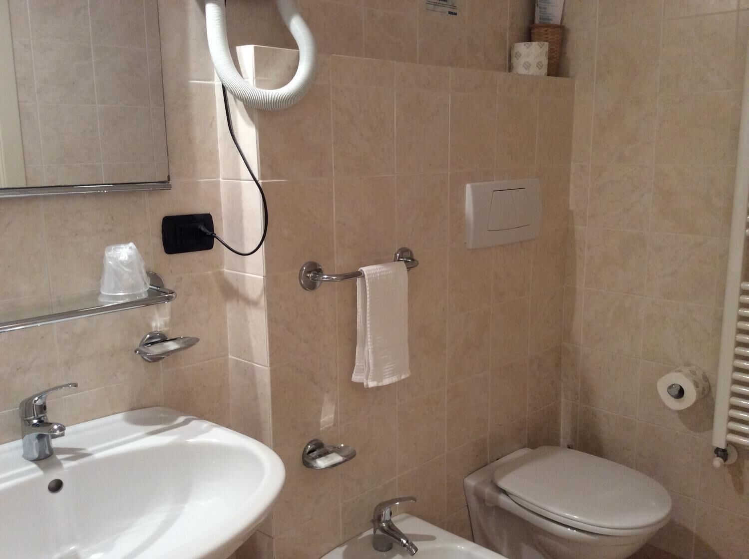 A bathroom with a sink, toilet, and shower area.