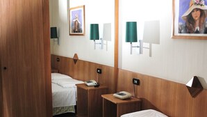 A hotel room with two beds, a wooden door, a mirror, and wall-mounted lamps. - Meranda (Spezzano della Sila)