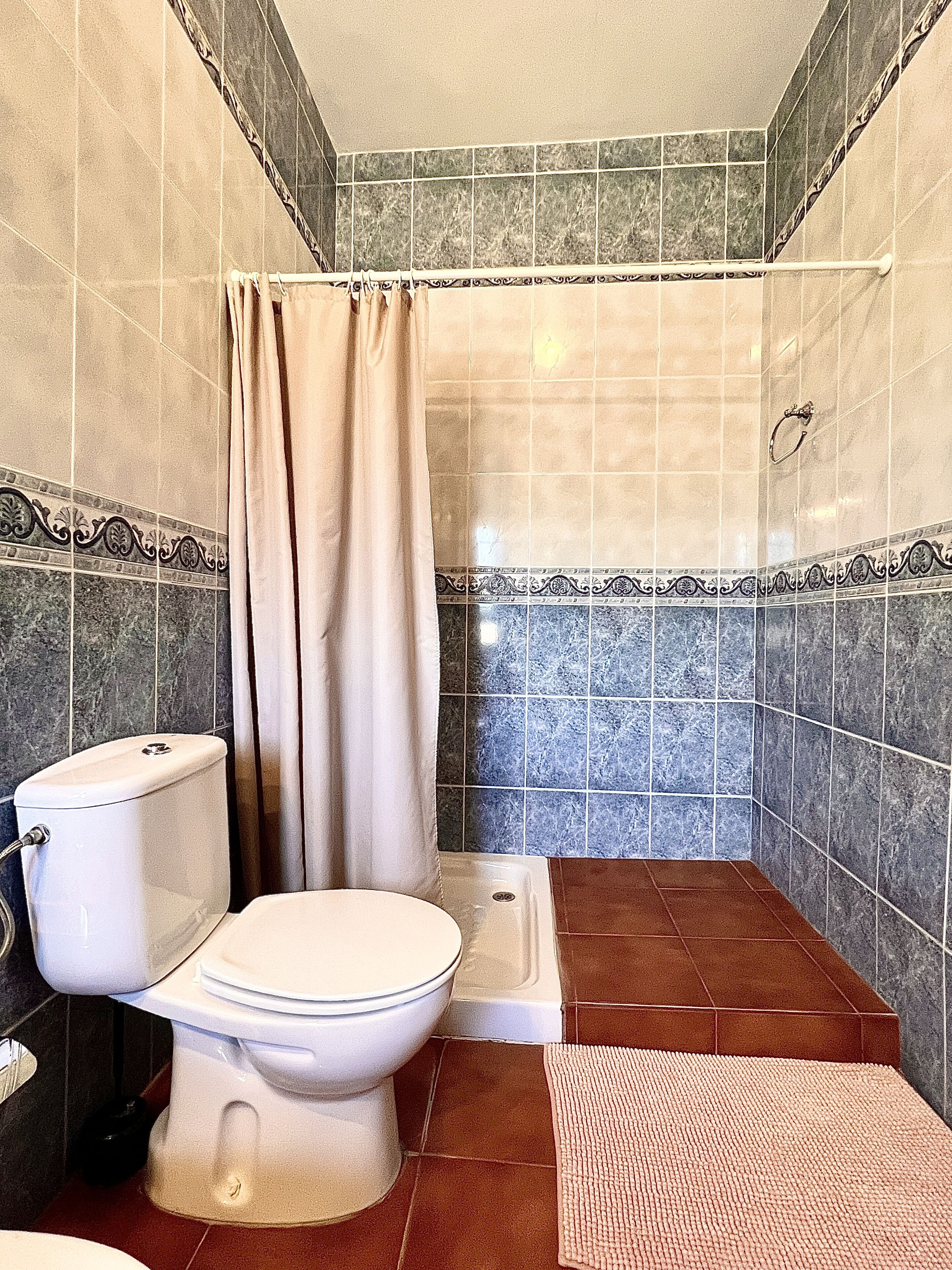 A bathroom with a toilet, shower, and bathtub.