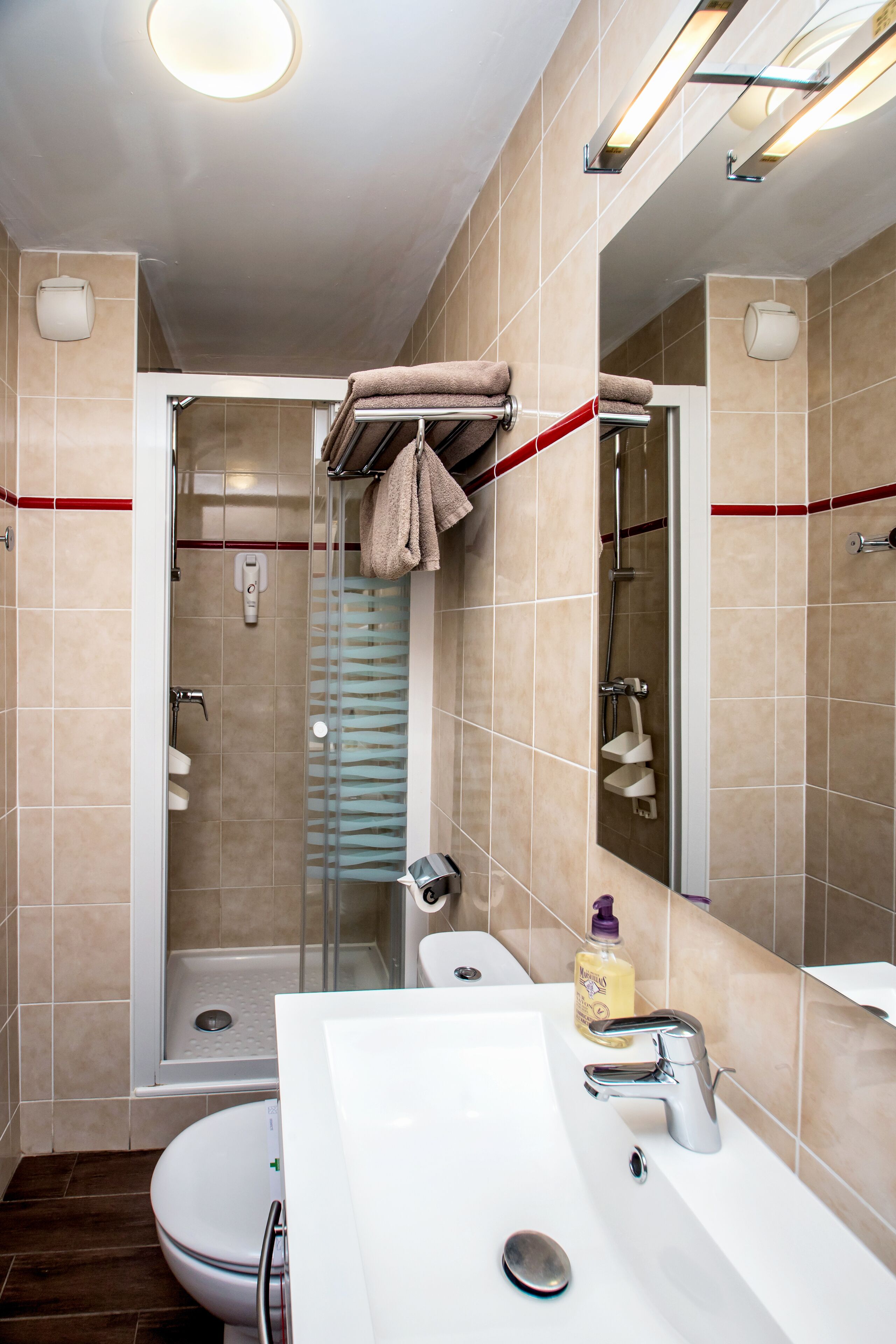 Une salle de bain moderne équipée d’une douche, de toilettes et d’un lavabo.