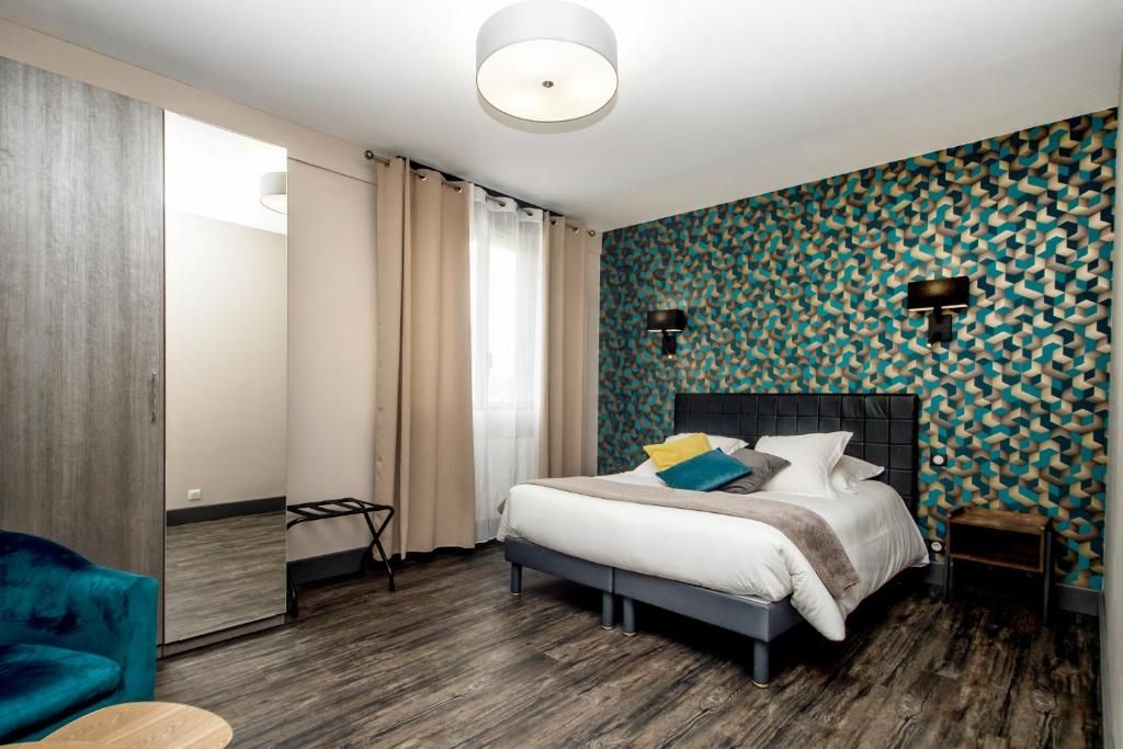Moderni hotellihuone, jossa on sänky, tuoli, pieni pöytä ja peili.