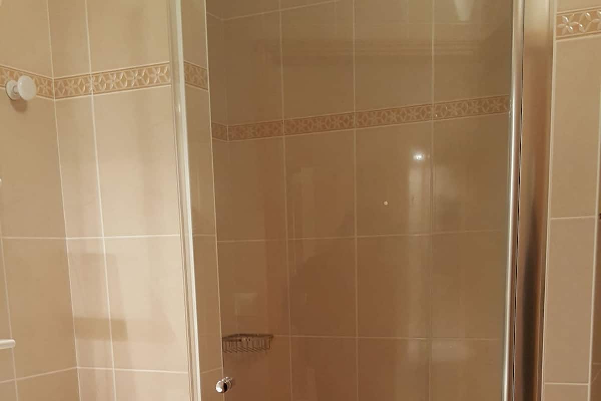 A bathroom with a shower, toilet, and sink.