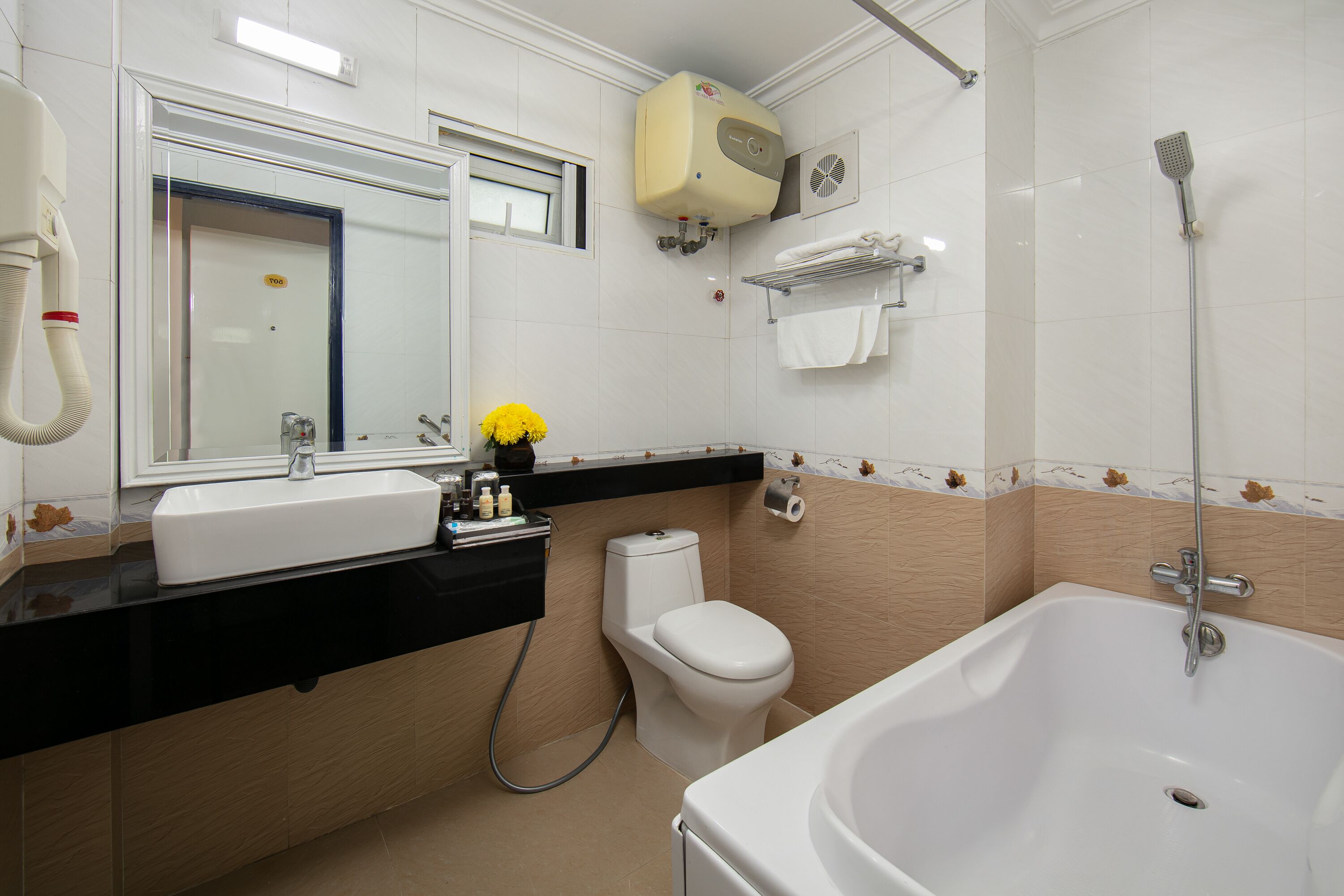 A bathroom with a white sink, toilet, and bathtub. There is a mirror above the sink, and a towel rack on the wall.