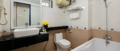 A bathroom with a white sink, toilet, and bathtub. There is a mirror above the sink, and a towel rack on the wall.