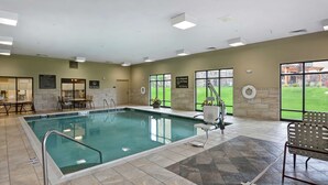 A large indoor swimming pool with clear signage, a lifeguard chair, and a view of the outdoors through large windows. - Hampton Inn and Suites New Hartford/Utica (New Hartford)