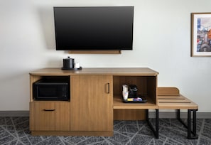 A compact hotel room with a wooden desk, a flat-screen TV, a microwave, and a coffee maker. - Hampton Inn and Suites New Hartford/Utica (New Hartford)