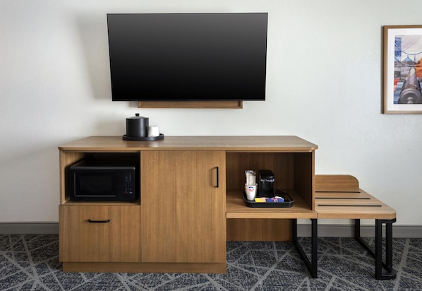 A compact hotel room with a wooden desk, a flat-screen TV, a microwave, and a coffee maker. - Hampton Inn and Suites New Hartford/Utica (New Hartford)