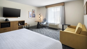A hotel room with a large bed, a desk, a chair, a television, and a window with curtains. - Hampton Inn and Suites New Hartford/Utica (New Hartford)