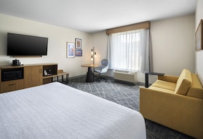 A hotel room with a large bed, a desk, a chair, a television, and a window with curtains. - Hampton Inn and Suites New Hartford/Utica (New Hartford)