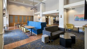 A hotel lobby with seating areas, a reception desk, and a staircase. - Hampton Inn and Suites New Hartford/Utica (New Hartford)