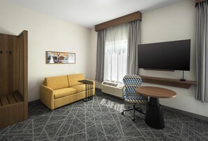 A hotel room with a sofa, a chair, a TV, a painting, and a window with curtains. - Hampton Inn and Suites New Hartford/Utica (New Hartford)