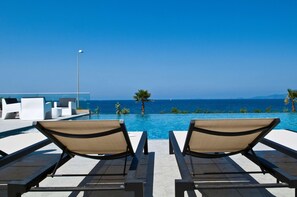 Una piscina al aire libre, sombrillas, tumbonas
