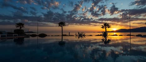 Una piscina al aire libre, sombrillas, tumbonas