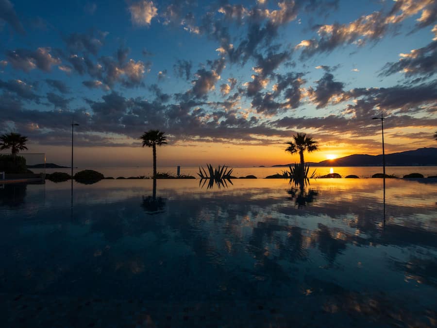 Een buitenzwembad, parasols voor strand/zwembad
