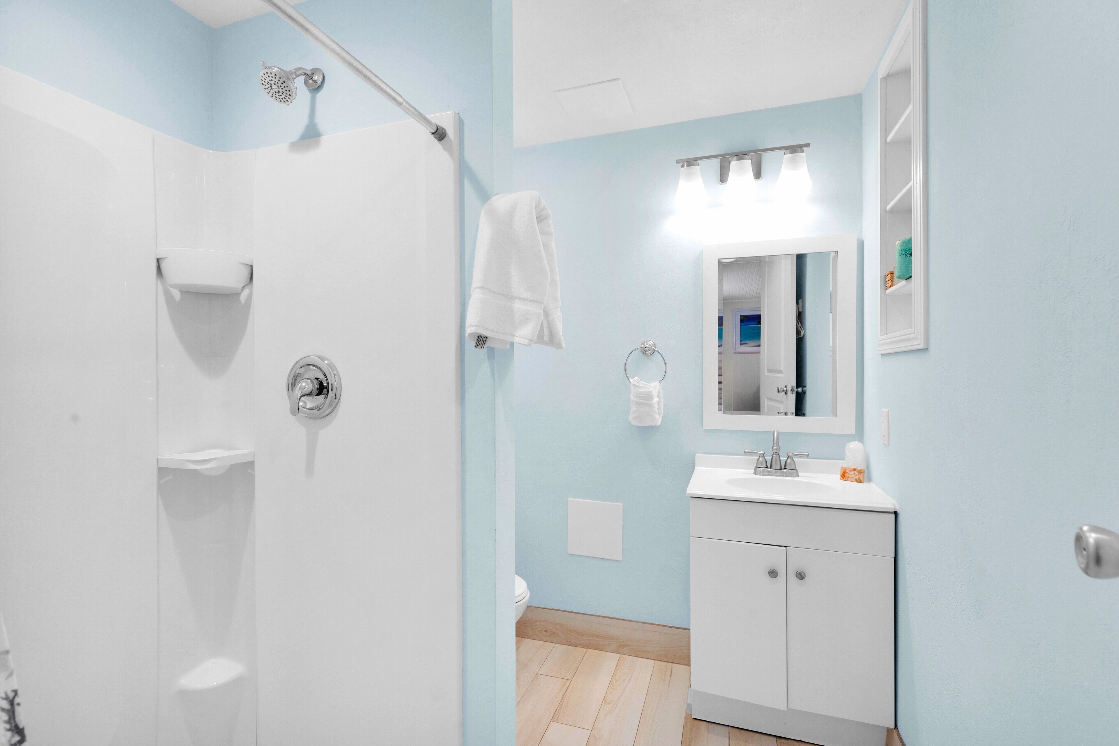 A bathroom with a shower, toilet, and sink.
