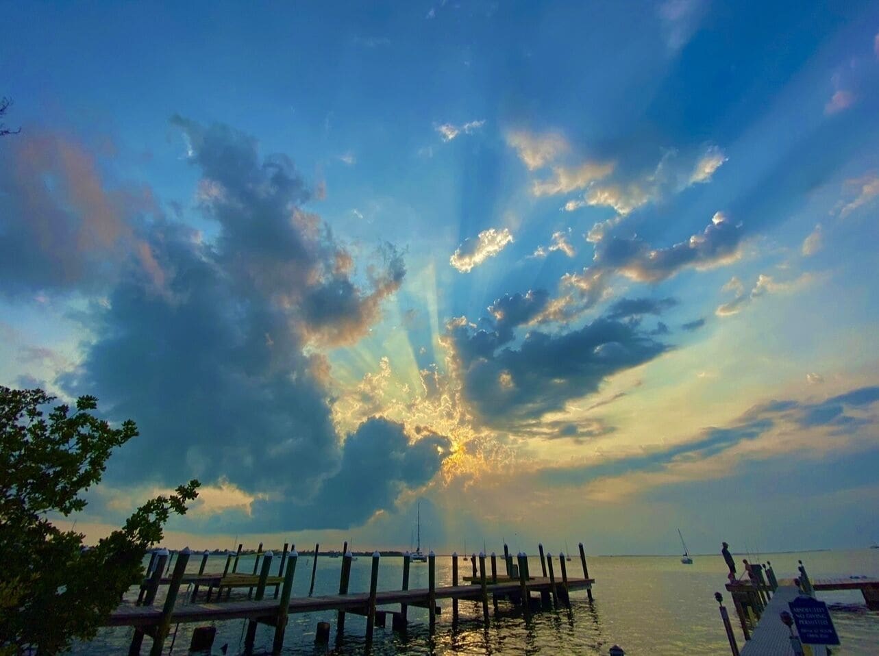 A pier extending into calm waters with a sunset sky.