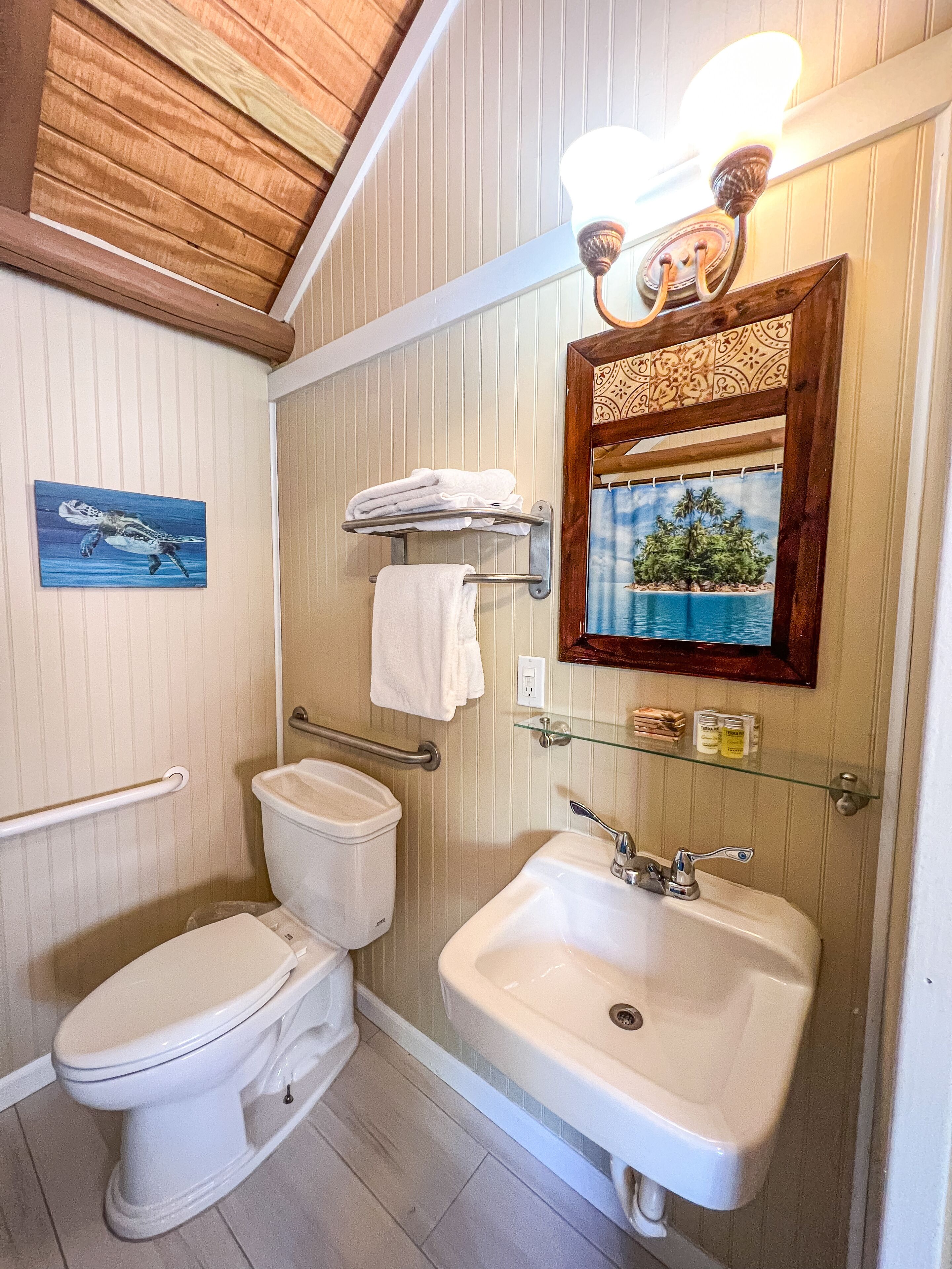 Une salle de bain équipée de toilettes, d’un lavabo et d’un porte-serviettes.