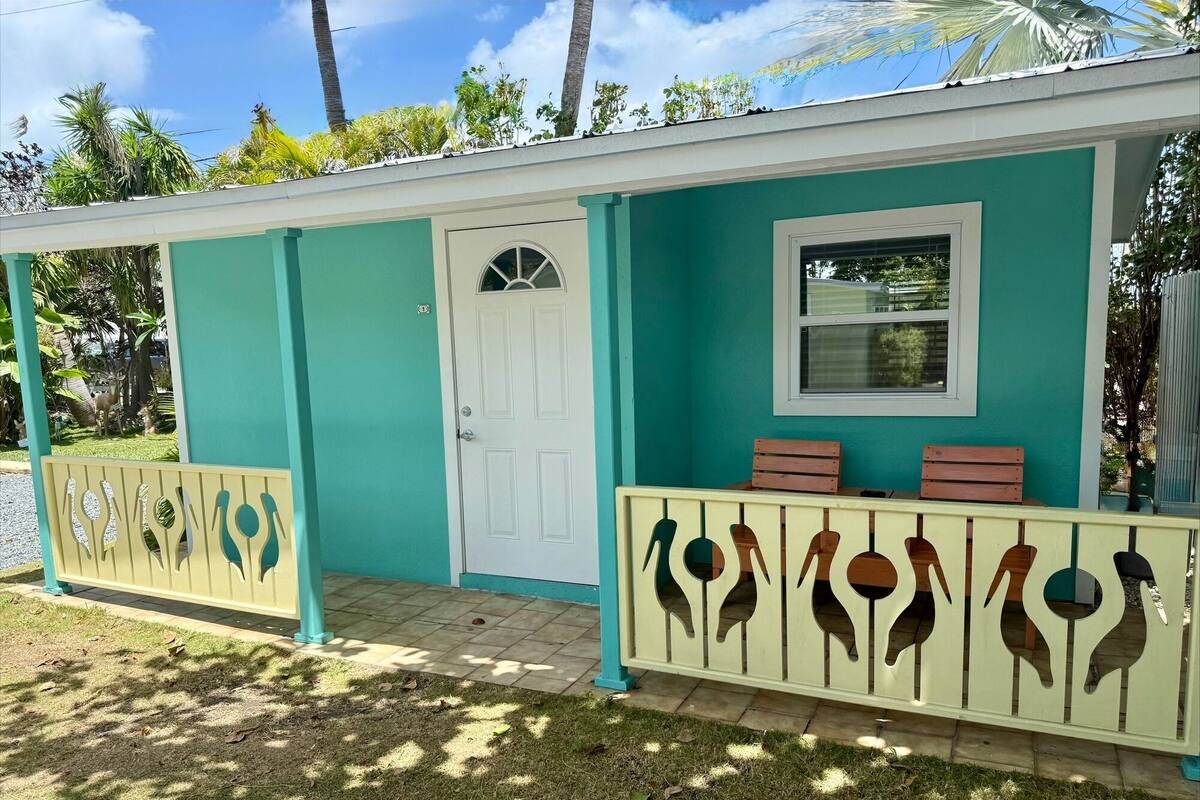 A house with a teal exterior, a white door, and a window.