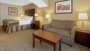 Ein Hotelzimmer mit einem Bett, einer Couch, einem Tisch und zwei Lampen.