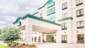 A hotel with a prominent green and white color scheme, a covered entrance, and a landscaped front yard. - Wingate by Wyndham Bossier City, LA (Bossier City)