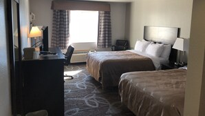 A hotel room with two beds, a desk with a lamp, a chair, and a window with curtains. - Quality Inn Spanish Fork North (Spanish Fork)