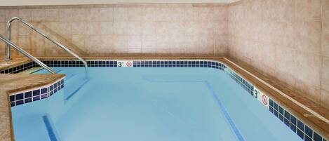 A swimming pool with a tiled wall, a metal ladder, and a '3 FT' depth marking.