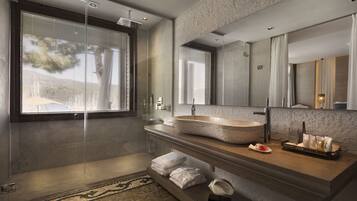 A modern bathroom with a large mirror, a stone sink, and a glass shower enclosure.
