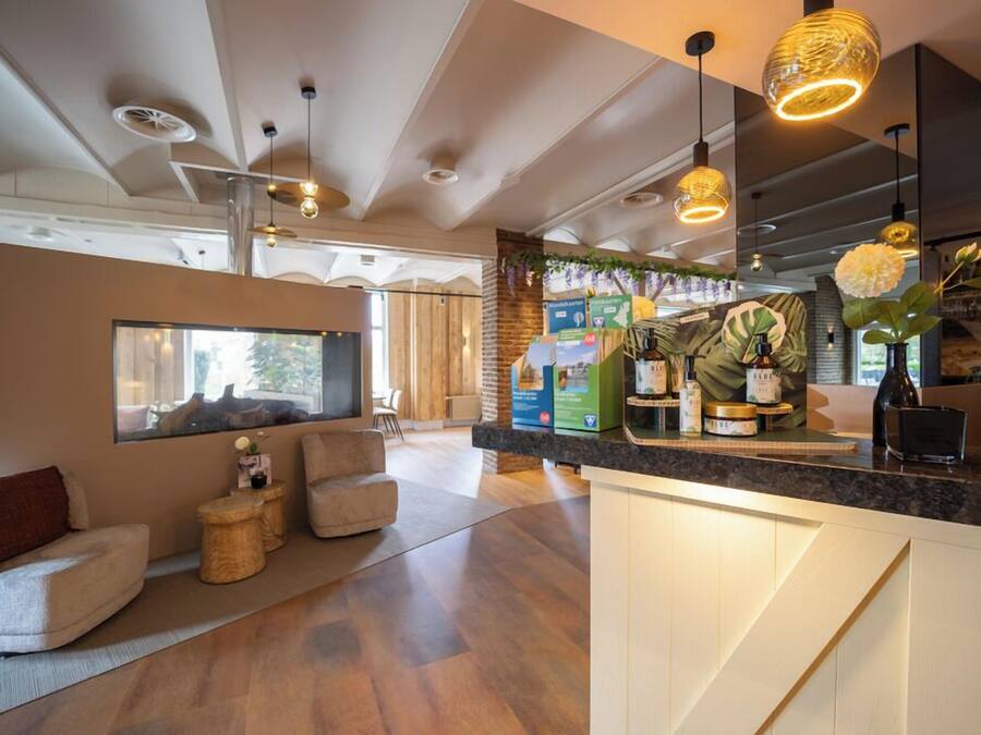 Una cocina moderna con una isla central, iluminación colgante y vistas al área de estar.