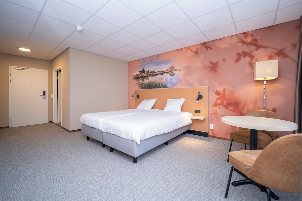 Ein Hotelzimmer mit einem Bett, einem runden Tisch und einem Stuhl.
