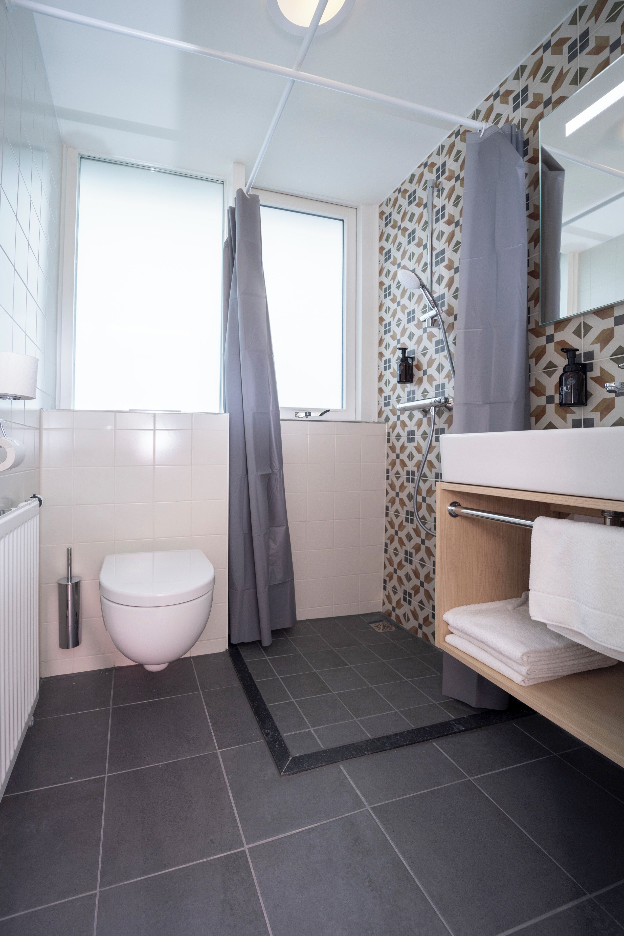 Un bagno moderno con un WC, doccia e un angolo lavabo.