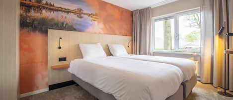 Una habitación de hotel con dos camas, un ventanal grande, un cuadro en la pared y una mesita de noche con una lámpara.