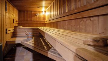 Een sauna met houten banken en een betegelde vloer.
