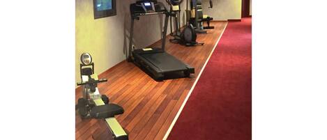 A gym with treadmills, stationary bikes, and weight machines.