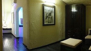 A room with a sofa, a small table, a framed picture on the wall, and a wooden cabinet. - The Rhino Resort Hotel & Spa (Mbour)