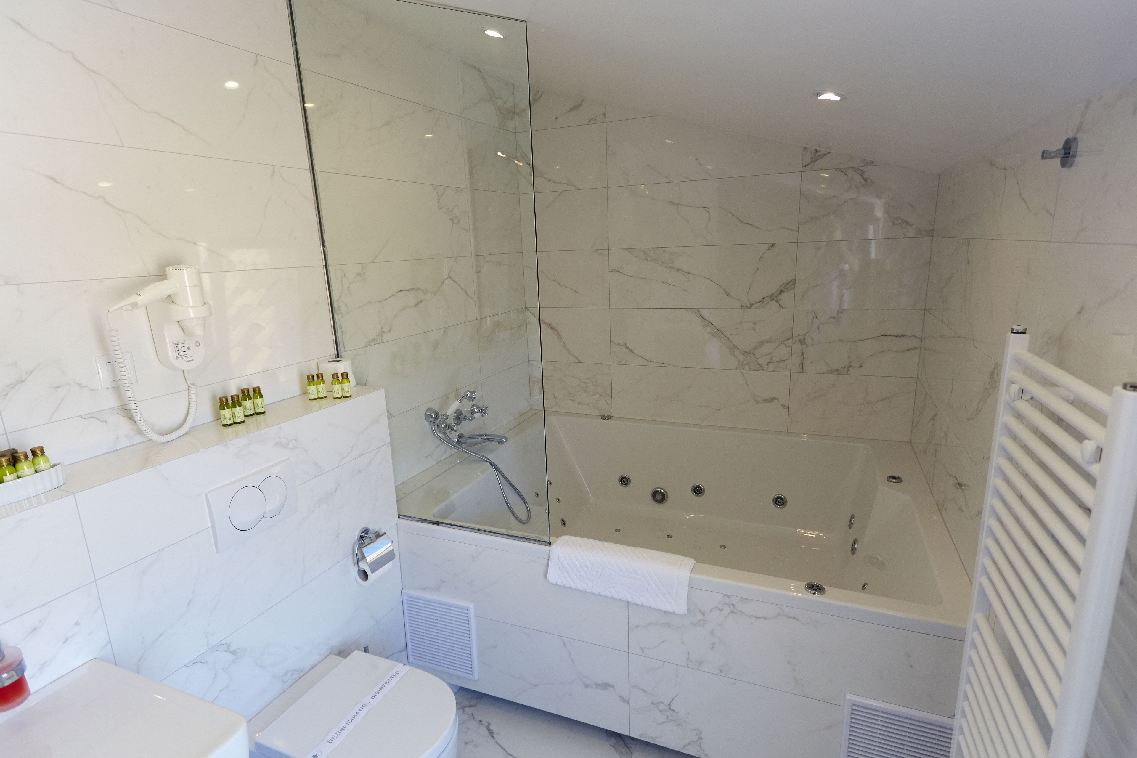 Une salle de bain moderne avec une douche à parois de verre, une baignoire sur pieds et des toilettes.