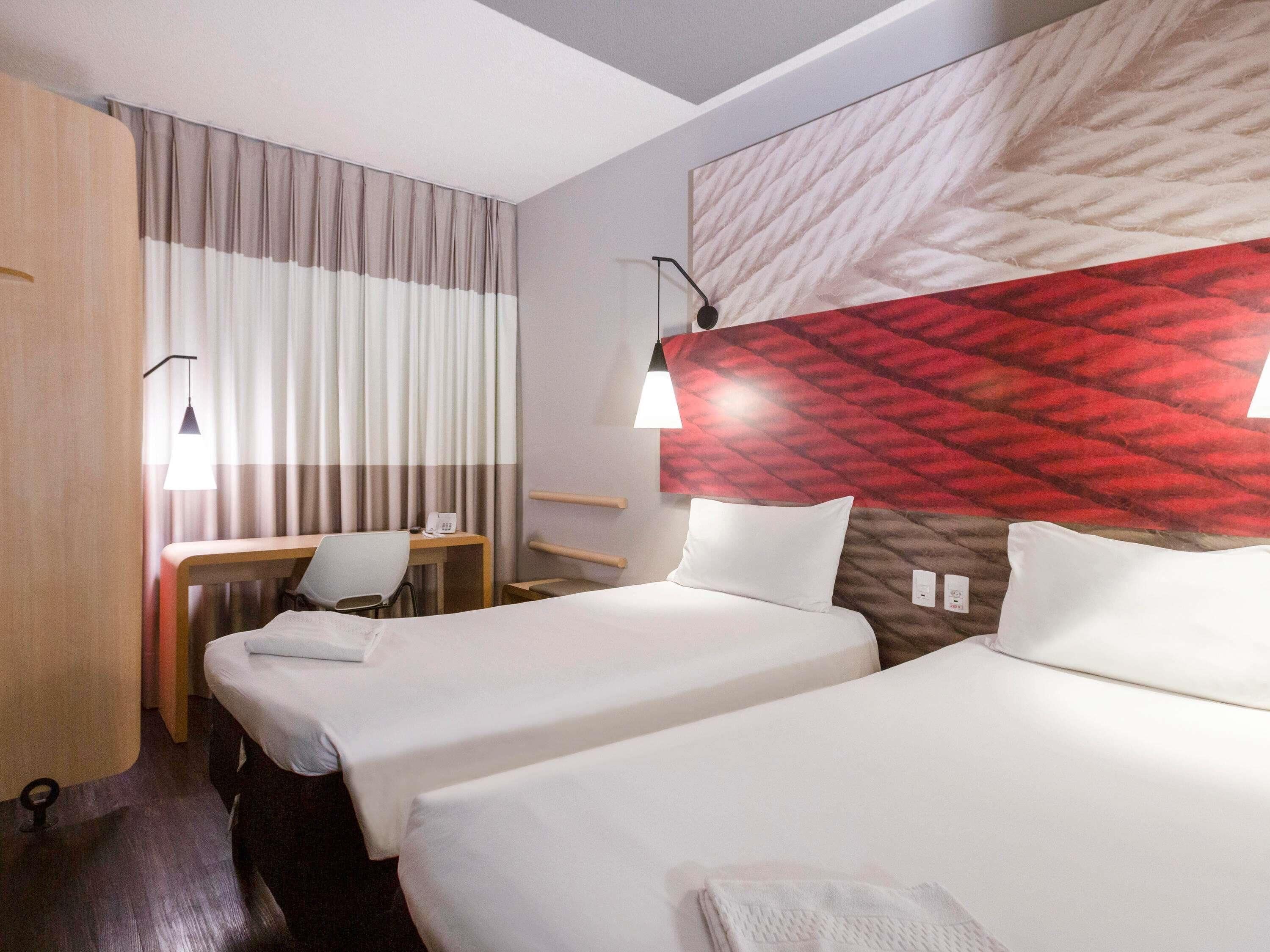 Una habitación de hotel con dos camas, un escritorio y una silla.